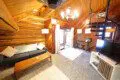 Warm log cabin living room in Fairbanks Alaska with wooden interior, couch, and spiral staircase