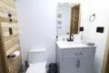 Rustic wood-accented bathroom with white vanity and natural light in Fairbanks Alaska