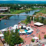Downtown Fairbanks summer event with tents, people, a large yellow duck, and river views at Golden Heart Plaza.