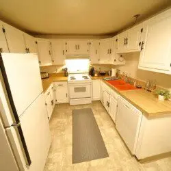 Rustic kitchen with white cabinets and wood accents in a Fairbanks Alaska cabin
