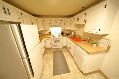 Rustic kitchen with white cabinets and wood accents in a Fairbanks Alaska cabin