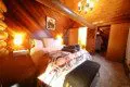 Rustic cabin bedroom with tribal blanket, soft lighting, and wooden walls in a Fairbanks, Alaska treehouse rental.