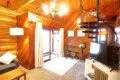 Warm log cabin living room in Fairbanks Alaska with wooden interior, couch, and spiral staircase