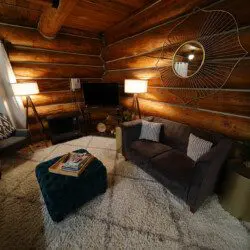 Rustic log cabin living room with modern furniture and soft lighting in Fairbanks Alaska