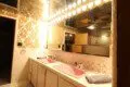 Retro-style bathroom with dual pink sinks, large mirrors, and warm vanity lighting in a Fairbanks Alaska lodge