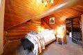 Rustic cabin bedroom with tribal blanket, soft lighting, and wooden walls in a Fairbanks, Alaska treehouse rental.