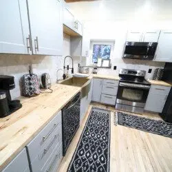 Sleek kitchen with light wood counters, gray cabinets, stainless steel appliances in a Fairbanks Alaska rental