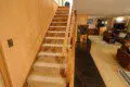 Carpeted staircase leading to upper level with laundry, overlooking cozy living space in Fairbanks Alaska lodge