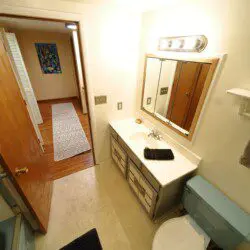 Well-lit bathroom with vanity and blue toilet in Fairbanks adventure lodge.