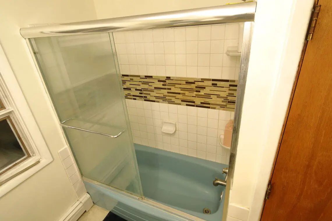 Well-lit bathroom with vanity and blue toilet in Fairbanks adventure lodge.