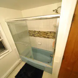 Well-lit bathroom with vanity and blue toilet in Fairbanks adventure lodge.