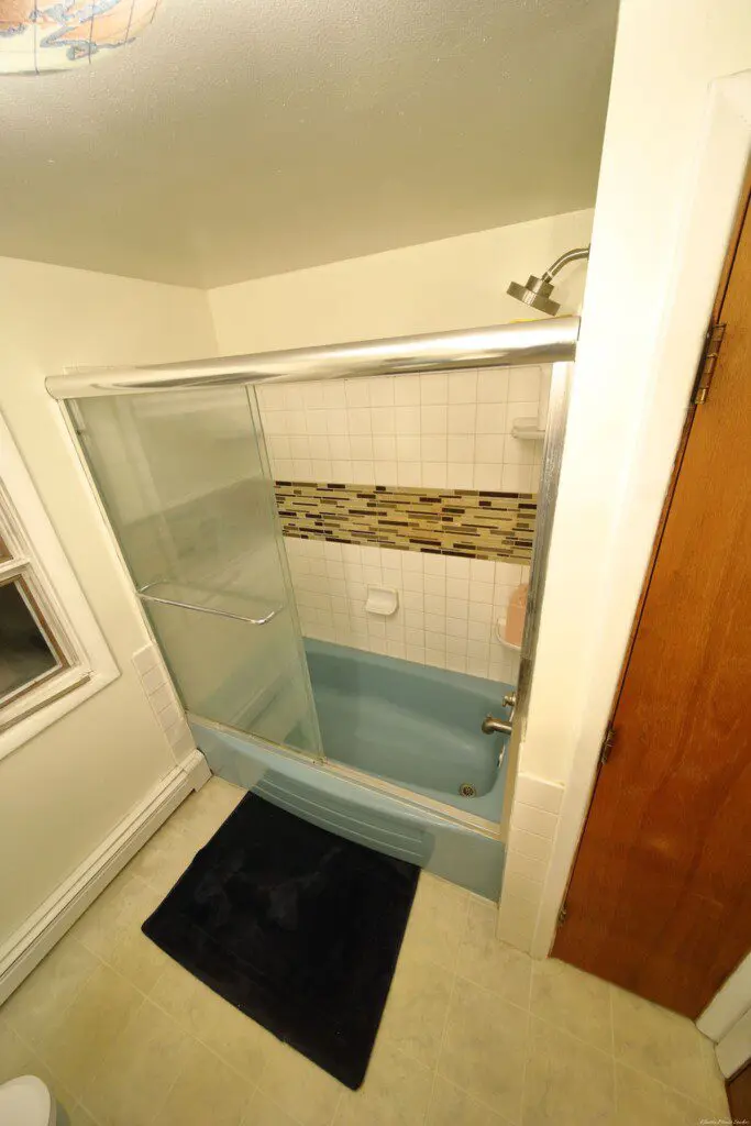 Well-lit bathroom with vanity and blue toilet in Fairbanks adventure lodge.