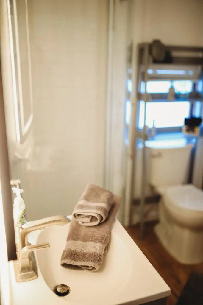 Modern bathroom with mirror and sink inside restored railcar lodge in Fairbanks.