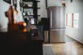 Stylish kitchen with stainless steel fridge, open shelves, and wood floors in a Fairbanks Alaska lodge