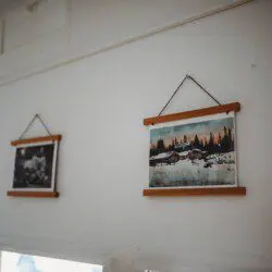 Framed historic Fairbanks prints on white wall in vintage railcar lodge.