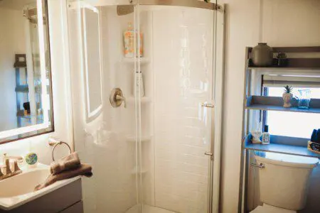 Bright bathroom with glass shower, shelves, and toilet in a stylish Fairbanks Alaska adventure rental