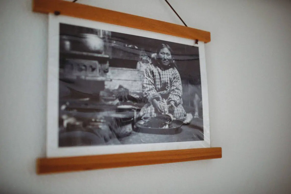 Framed historic Fairbanks prints on white wall in vintage railcar lodge.