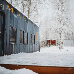 Historic railcar lodging with snowy deck and winter trees in Fairbanks Alaska
