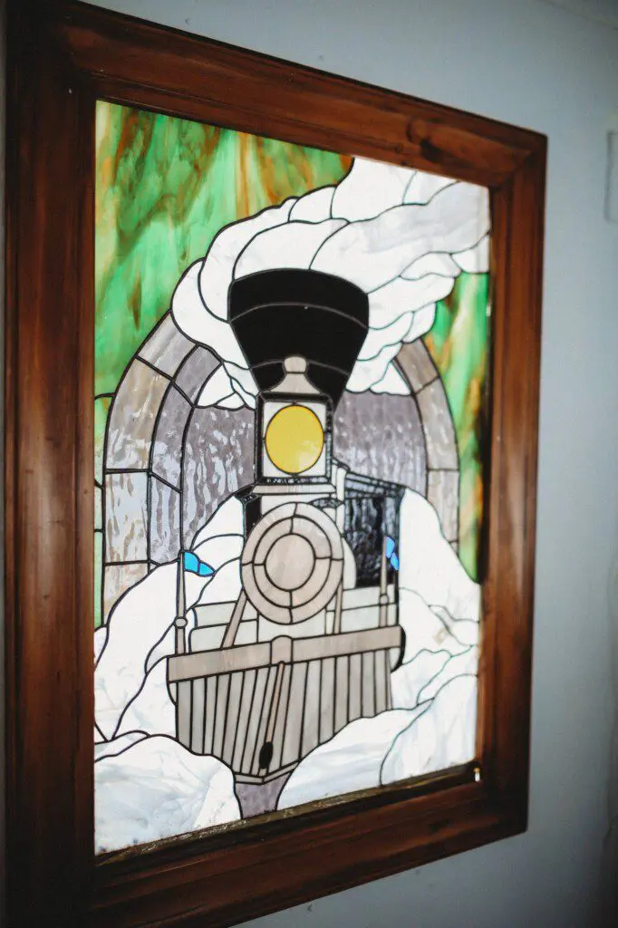 Framed historic Fairbanks prints on white wall in vintage railcar lodge.