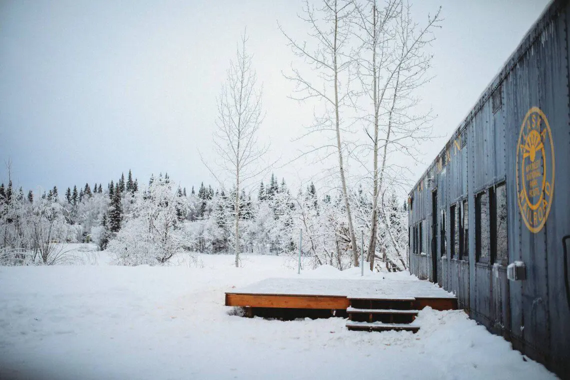 Snow-covered Alaska Railroad car lodge stay in Fairbanks adventure setting.