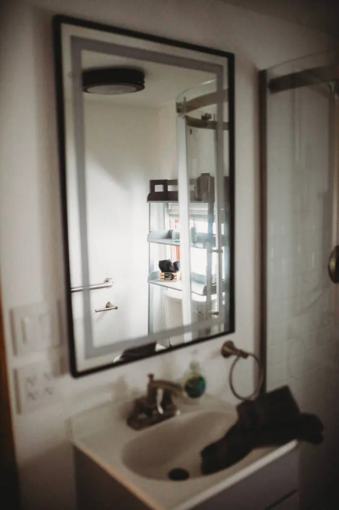 Modern bathroom with mirror and sink inside restored railcar lodge in Fairbanks.
