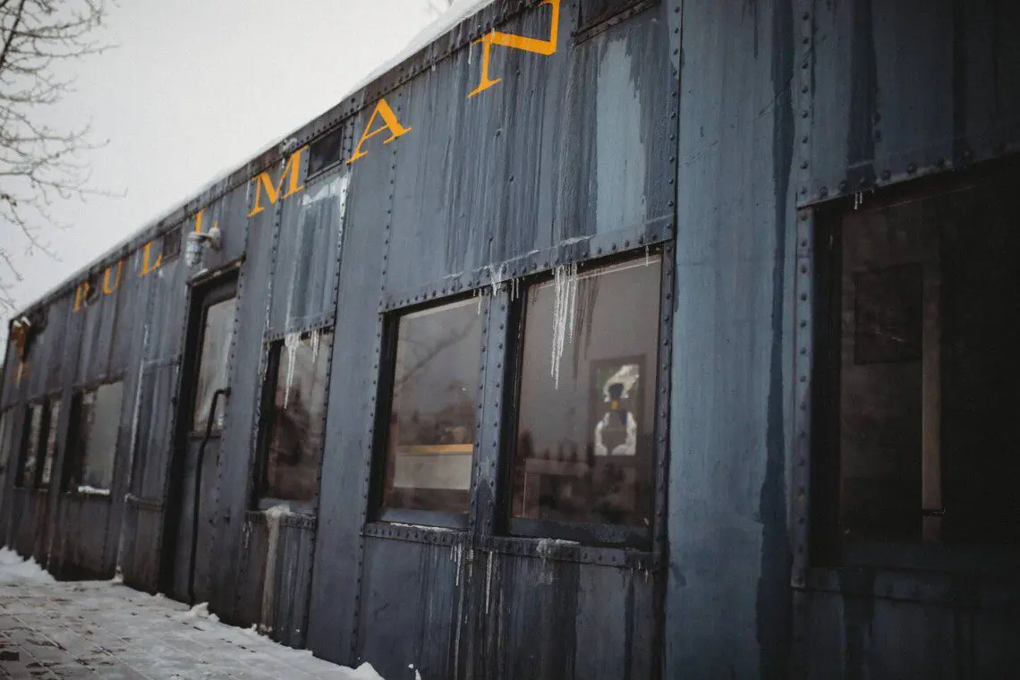 Close-up of weathered blue Pullman train car with icicles, repurposed as lodging in Fairbanks Alaska