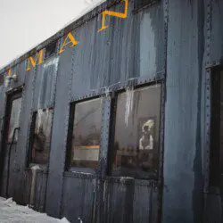 Close-up of weathered blue Pullman train car with icicles, repurposed as lodging in Fairbanks Alaska