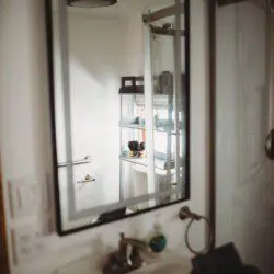 Modern bathroom with mirror and sink inside restored railcar lodge in Fairbanks.