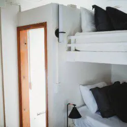 White bunk beds inside restored railcar at Alaska adventure lodge in Fairbanks.