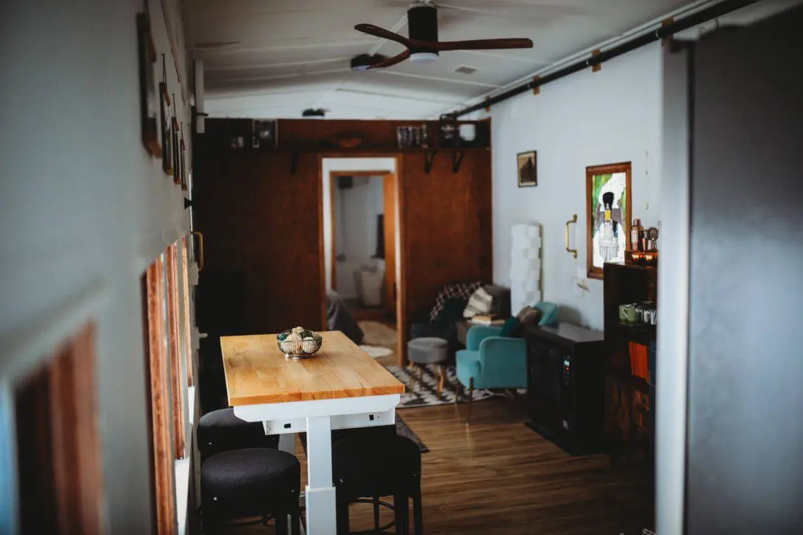 Modern open-plan interior with dining table, ceiling fan, and cozy seating in a Fairbanks Alaska lodge  Caption:
