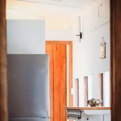 Small modern kitchen with refrigerator, bar stools, and windows in a Fairbanks Alaska lodge