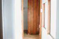 Narrow hallway with wooden door, white walls, and natural light in a Fairbanks Alaska adventure lodge