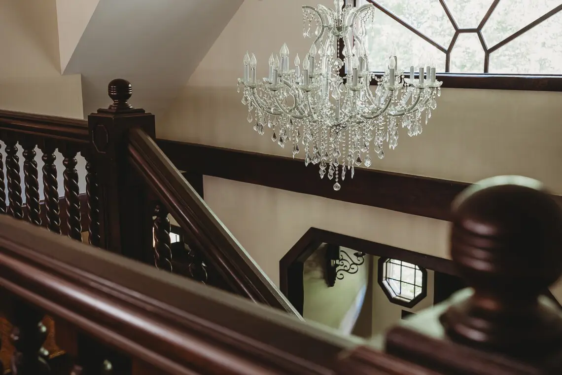 Crystal chandelier above wooden staircase in a unique Fairbanks Alaska adventure lodge rental
