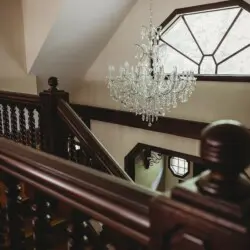 Crystal chandelier above wooden staircase in a unique Fairbanks Alaska adventure lodge rental