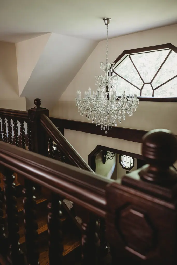 Crystal chandelier above wooden staircase in a unique Fairbanks Alaska adventure lodge rental