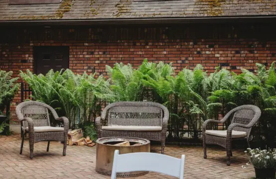 Wicker chairs and fire pit on brick patio at treehouse-style Alaska adventure lodge in Fairbanks