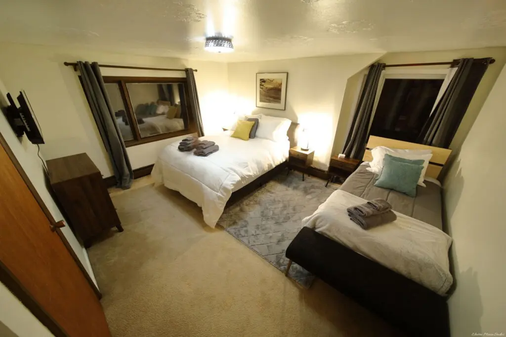 Inviting bedroom with two beds, soft lighting, and modern decor in a unique Fairbanks Alaska lodge