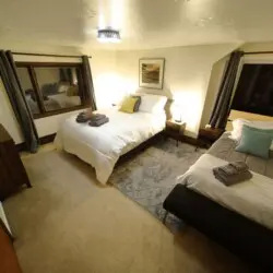 Inviting bedroom with two beds, soft lighting, and modern decor in a unique Fairbanks Alaska lodge