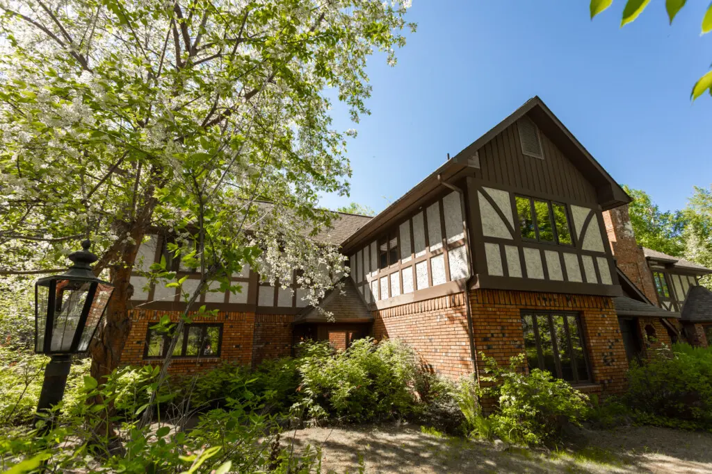 Exterior of Tudor-style lodge surrounded by trees in Fairbanks, ideal for weddings and adventure stays