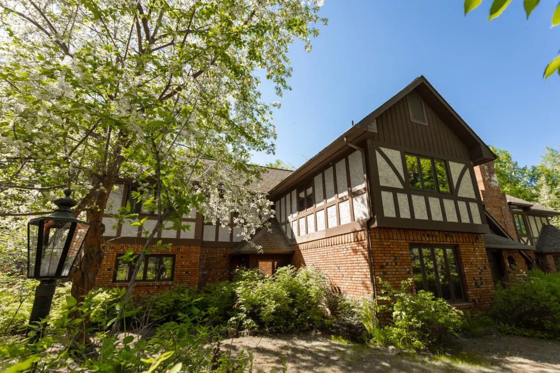 Exterior of Tudor-style lodge surrounded by trees in Fairbanks, ideal for weddings and adventure stays