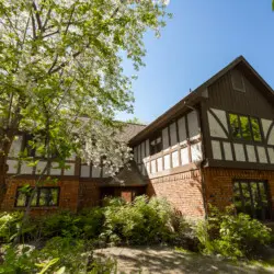 Exterior of Tudor-style lodge surrounded by trees in Fairbanks, ideal for weddings and adventure stays