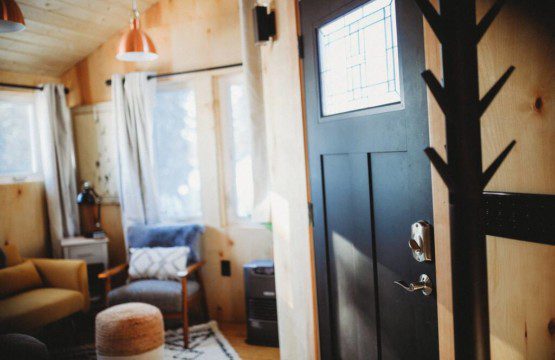 Inviting Fairbanks treehouse interior with hammock, teal sofa, cozy rug, and natural wood decor