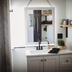 White bathroom vanity with mirror, plants, and shelves inside Fairbanks Alaska treehouse