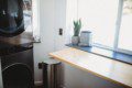 Black stacked washer and dryer in compact laundry nook of Fairbanks treehouse rental