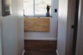 Narrow hallway with wood flooring and window view in a Fairbanks Alaska treehouse rental