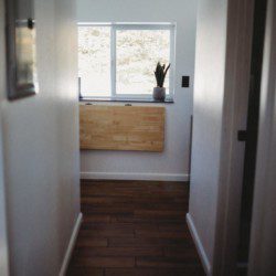 Narrow hallway with wood flooring and window view in a Fairbanks Alaska treehouse rental