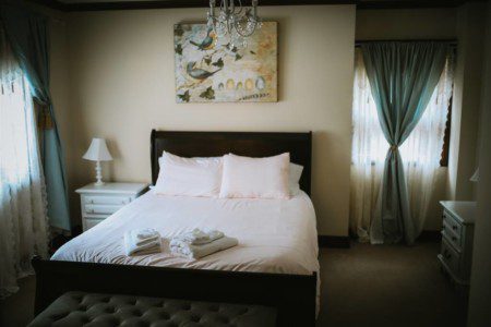 Cozy Fairbanks lodge bedroom with two beds, red towels, pillows, and warm lighting—ideal for wedding or adventure stays