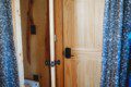 Wood-paneled bathroom with curtain doorway and view of toilet in a cozy Fairbanks Alaska treehouse rental