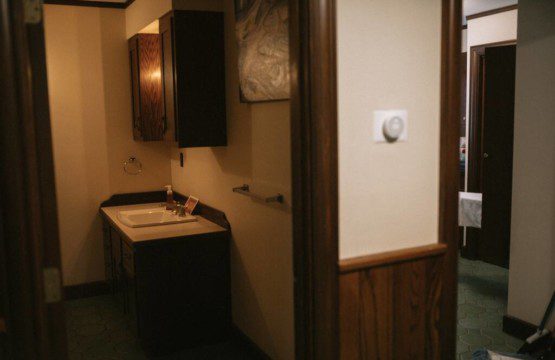 Vintage-style sink and cabinet area in a cozy Fairbanks Alaska rental with wood accents