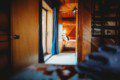 View through wooden hallway into a warmly lit bedroom in a Fairbanks Alaska cabin